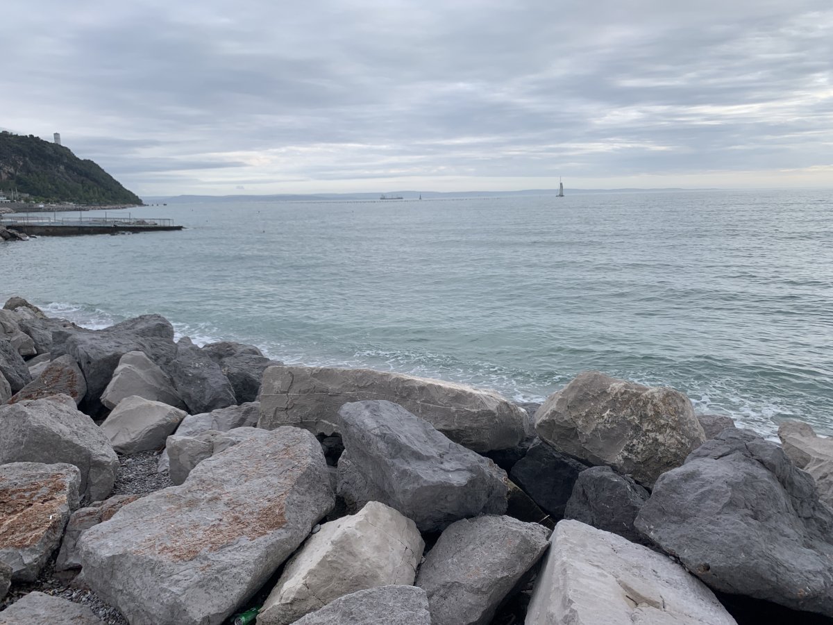 Rock defences at Sistiana harbour, long pebble beach to the left.. Rock defences at Sistiana harbour, long pebble beach to the left..