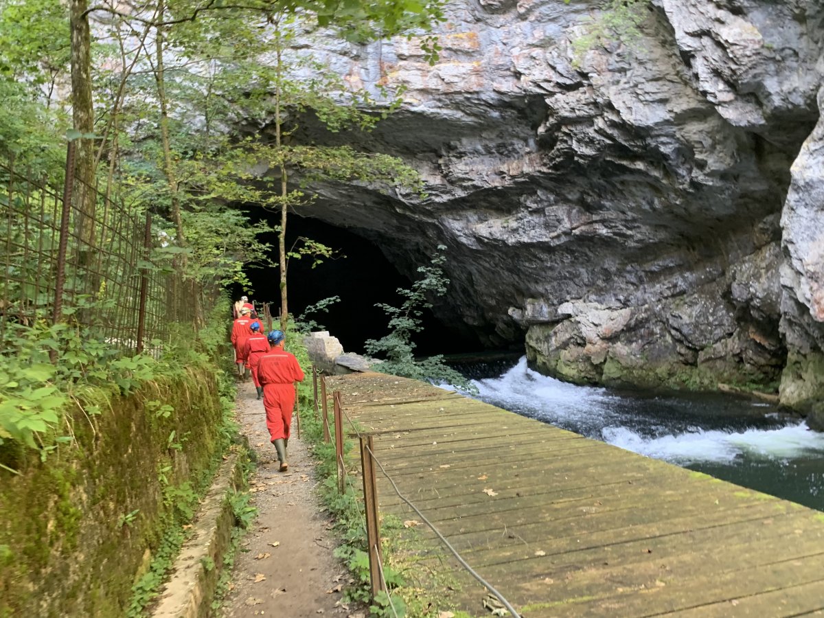 Teletubbies march into the massive mouth of the cave..